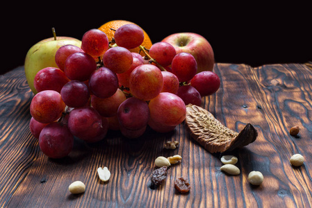 老木背景上的葡萄和水果