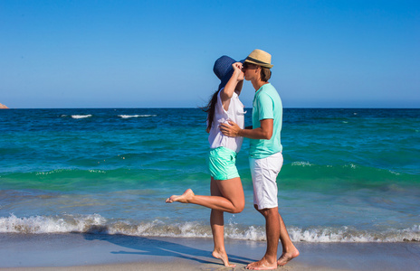 美丽的年轻夫妇，在热带度假期间在海滩散步