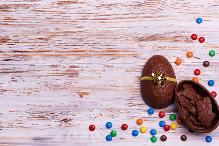 巧克力复活节彩蛋和五颜六色的糖果在一个轻木背景。甜点复活节假期概念