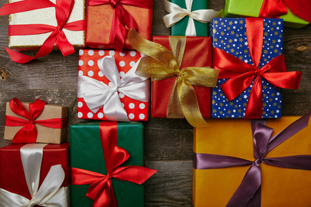 平躺在圣诞礼物包裹在不同的包装纸与丝带在木表面
