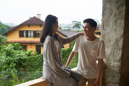 年轻的越南夫妇在阳台上欢笑和聊天