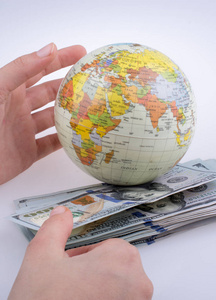 白色背景上的 aamerican 港元纸币身边的人类手的地球模型