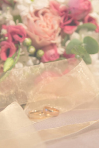 婚礼模糊背景 结婚戒指与自然玫瑰花束垂直