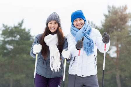 两个年轻快乐的滑雪者看着相机, 而享受冬季在公园