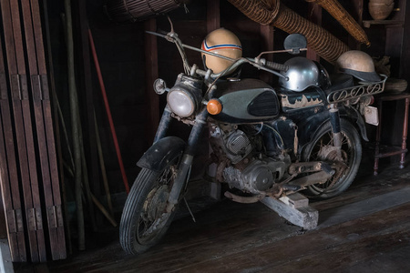 古代经典摩托车停放在一座带头盔的木屋里