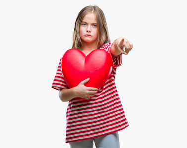 年轻美丽的女孩抱着红色的心在孤立的背景指向相机和你, 手势, 正面和自信的手势从前面