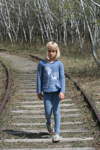 沿铁路轨道行走的年轻女孩