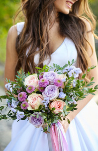 一个美丽的新娘花束紫色, 粉红色的玫瑰和绿叶。特写。艺术品
