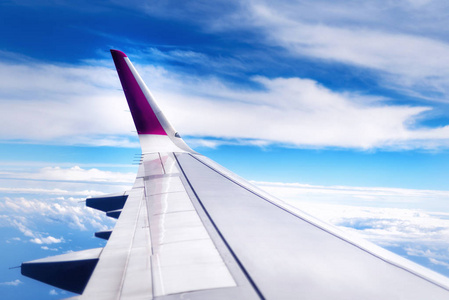 旅游理念。飞机的机翼飞越天空上空的云层。复制空间
