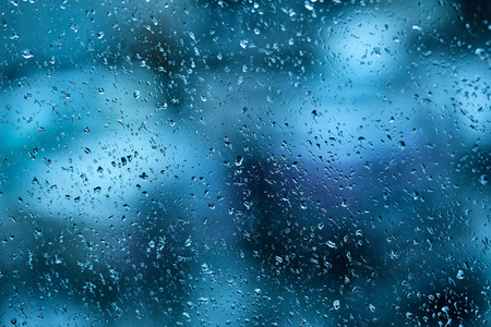清晨, 汽车挡风玻璃上的雨滴。透明玻璃经过雨后, 冷抽象照片。傍晚时分散落雨滴和模糊背景的玻璃质地