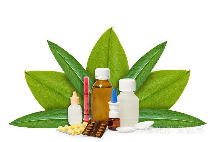 瓶与药药片在绿色叶子的背景查出的白色自然起源概念