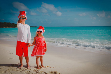 孩子男孩和女孩在热带海滩庆祝圣诞节