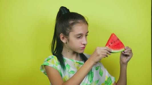 可爱开朗的女孩吃西瓜, 在黄色背景