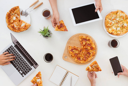 午餐和人的概念。快乐的商务团队在办公室里吃披萨