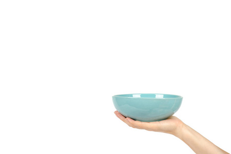蓝色空陶瓷碗与手查出的白色背景, 复制空间模板