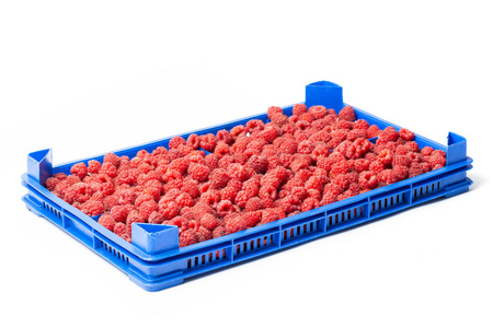 新鲜成熟的红莓在一个塑料板条箱上的批发市场上孤立的白色