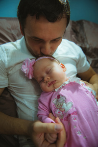 形象的年轻爸爸带着可爱的小女儿，在他的怀里