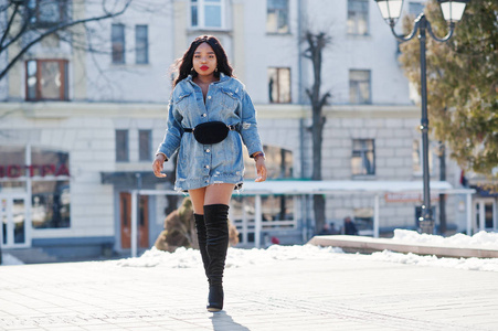 穿着牛仔裤的非洲裔美国女孩在城市的街道上摆姿势。B
