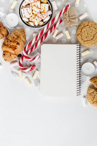 冬天平躺。热巧克力或可可糖, 饼干, 笔记本, 白色背景