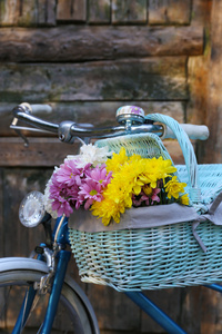 与花在金属筐篮辆旧自行车，旧的棕色门背景