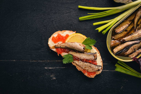 三明治与鲱, 鱼子酱, 洋葱, 在一个木制的背景。顶部视图。复制空间