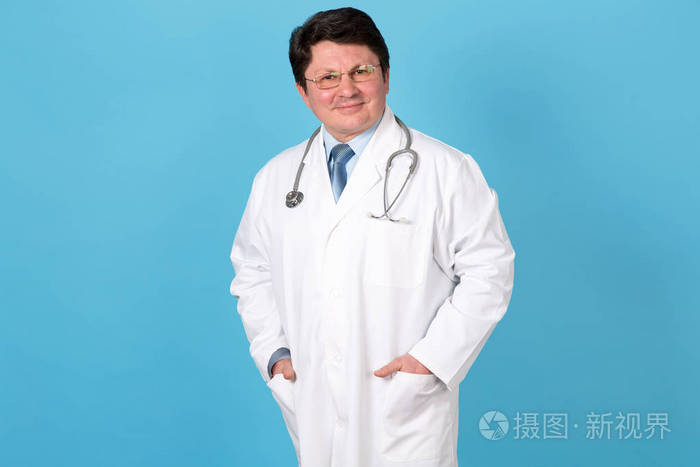 一个蓝色背景上的男性医生的肖像.中年男子.笑脸