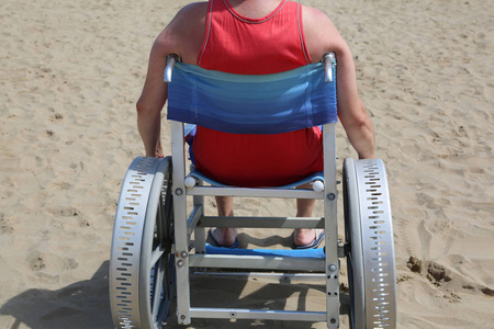 夏季沙滩上的特殊轮椅成人