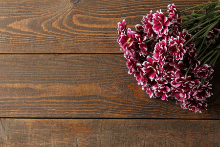 在褐色的木桌上, 有一个题字的地方菊花的秋天花的框架。顶部视图