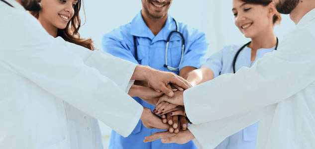 医生和护士堆叠的手。互助的概念