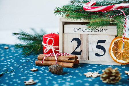 木日历与12月25日日期在它在绿色的地方垫, 蜡烛, 杉木树, 干桔子, 松树。圣诞庆典, 明信片概念