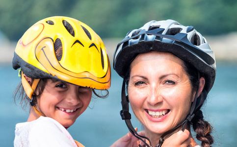快乐的母亲和女儿与自行车头盔