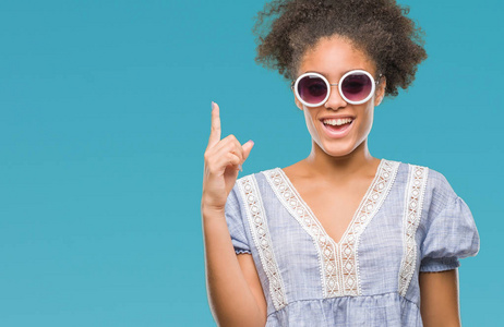 年轻的美国黑人妇女戴着眼镜在孤立的背景下, 指着成功的想法。退出和快乐。第一个