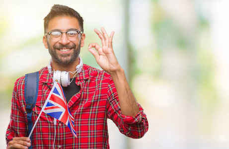 成人西班牙裔学生男子持有英国护照在孤立的背景下做 ok 标志与手指, 优秀的标志