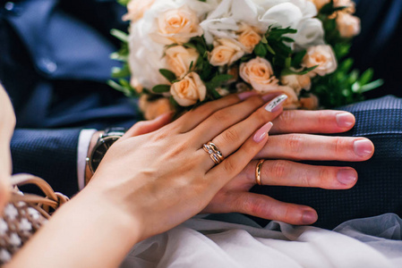 新娘和新郎的手与金戒指在婚礼当天一起