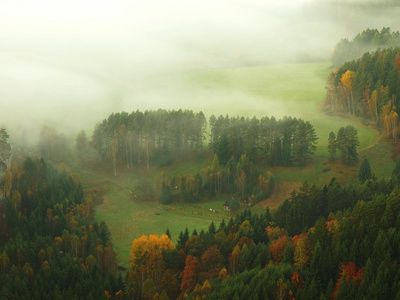 在薄雾笼罩的山谷上空的砂岩山峰上的观点。在美丽的山的捷克萨克森瑞士日出