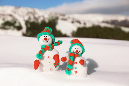 两个玩具雪人在山度假村在阳光明媚的寒冷的一天。寒假