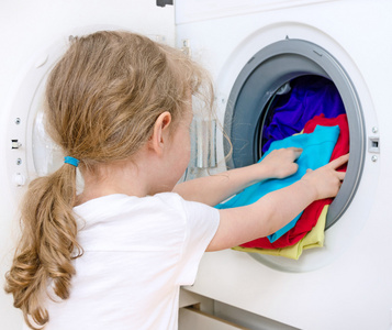 洗衣服的小女孩。家务劳动概念