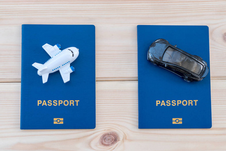 蓝色护照上的小玩具飞机和玩具汽车