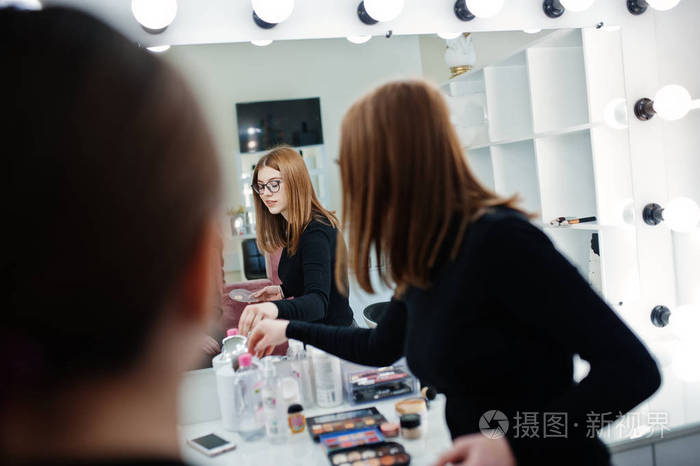 化妆师工作在她的美容美发工作室沙龙.女性应用程序