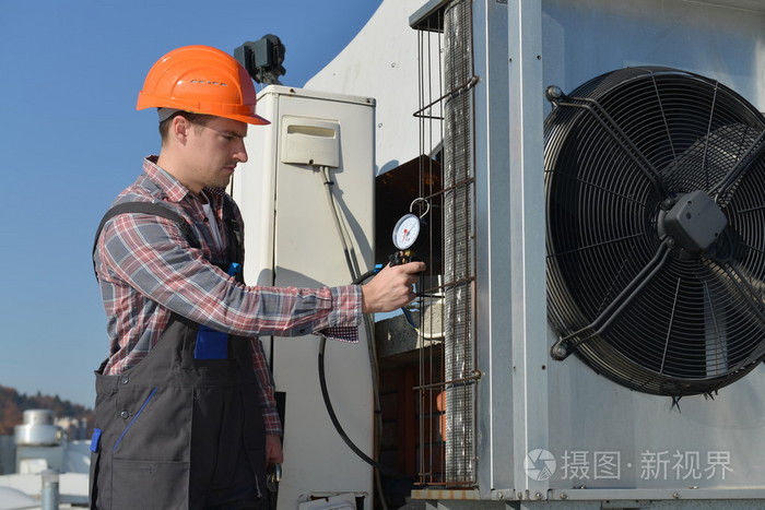 年轻修理工修理空调系统的屋顶上