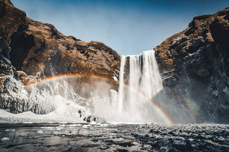 Skogafoss 瀑布在冰岛与彩虹在晴朗的天与蓝色的天空