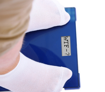 胖在电子秤上白色孤立。减肥的概念照片