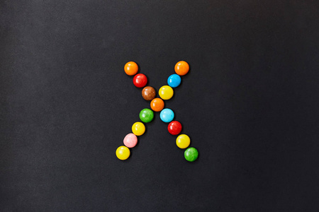用彩色糖果做的英文字母表。字母 X