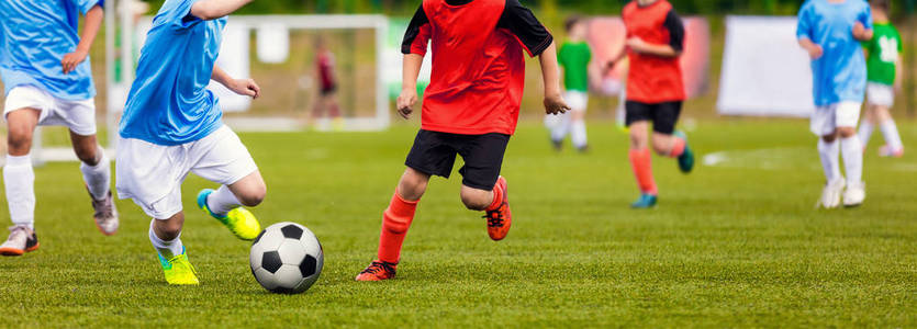 年轻的初中足球比赛。球员奔跑和踢足球球