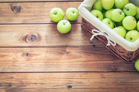 在一张木桌上的购物篮里的苹果