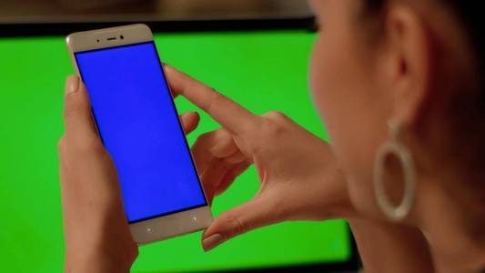 女孩用蓝色屏幕在电话中制作视频电话