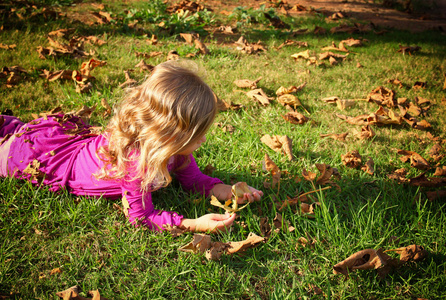 在公园的草地上玩耍的小的可爱的女孩。已过滤的图像