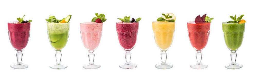 一套经典的新鲜美味的冰沙装饰与水果和浆果隔离在白色的背景。纯素食天然健康饮品