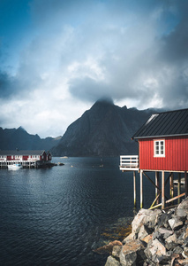 彩虹 ofer 红房子罗布尔的女王, 在挪威的弗洛罗的房子, 云彩, 阴雨蓝天和阳光明媚。背景中的桥梁和山脉