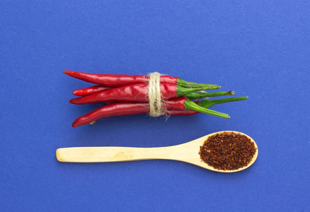 顶部视图, 红辣椒, 绑在一个蓝色的背景辫子和木勺